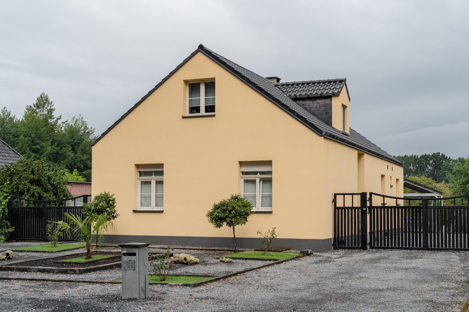 Woning afgewerkt met gele gevelbepleistering